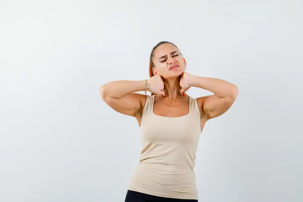 chica con dolor de cuello luciendo molesta