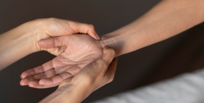 fisio tocando la muneca del paciente