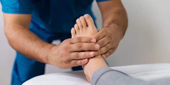 osteopata masajeando el pie del paciente